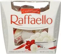 Close-up of a Raffaello confection, showcasing its delicate white exterior, coconut flakes, and hint of the almond center.