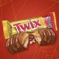 Close-up of a Twix bar, displaying its layers of crunchy cookie, smooth caramel, and milk chocolate.