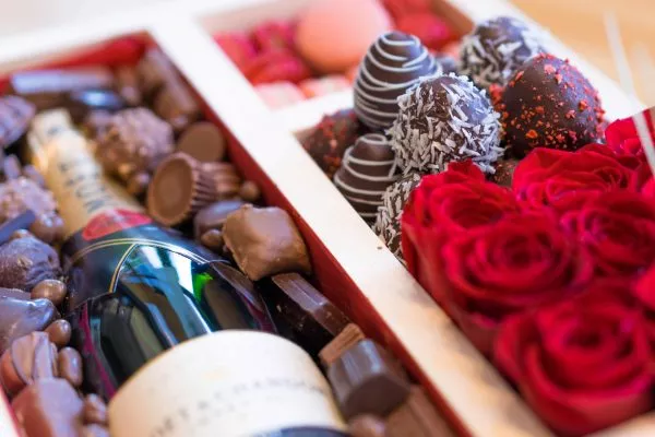 High-end gift box, perfect for gifting, with top-notch champagne, colorful flower bouquet, assorted macaroons, and mouth-watering chocolate strawberries.