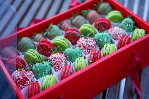 Top view of the open Holly Jolly box, showcasing the intricate arrangement of strawberries and macarons