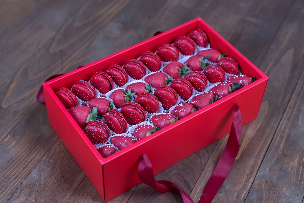 Elegant box of chocolate-covered strawberries and red macarons