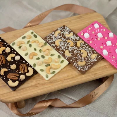 Assortment of Nut Collection gourmet chocolate bars with premium nuts: dark, white, milk, and pink chocolates.