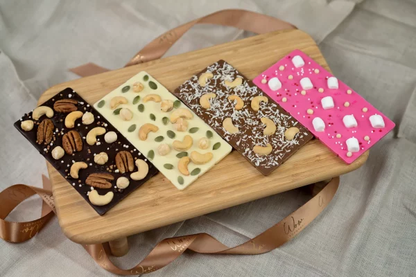 Assortment of Nut Collection gourmet chocolate bars with premium nuts: dark, white, milk, and pink chocolates.