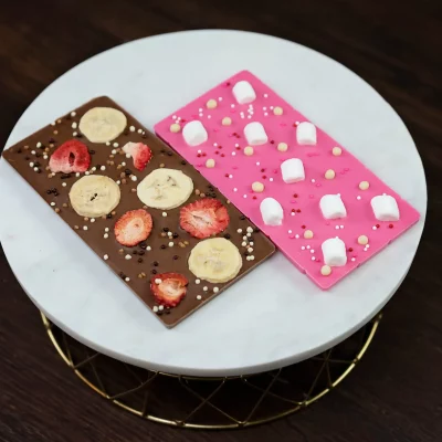 Artisanal chocolate bars: milk chocolate with bananas and strawberries, white chocolate with marshmallows.