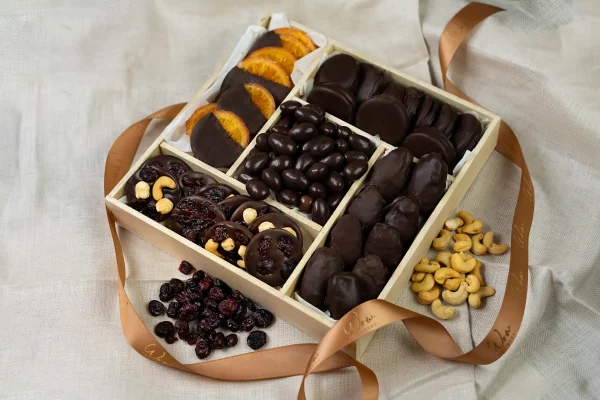 A luxurious 10x10 inch Chocolate Decadence Gift Box containing chocolate mendiants, chocolate covered almonds, Oreos, orange slices, and dates.