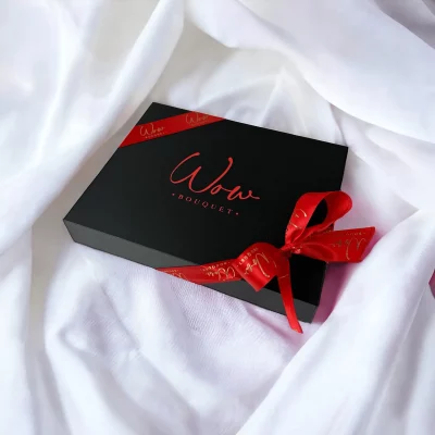Closed luxurious gift box of chocolate treats tied with a glossy red ribbon, symbolizing elegance and taste.